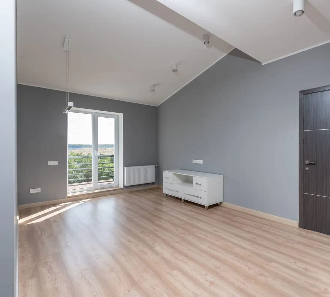 Pièce intérieure terminée, plancher de bois et grande fenêtre