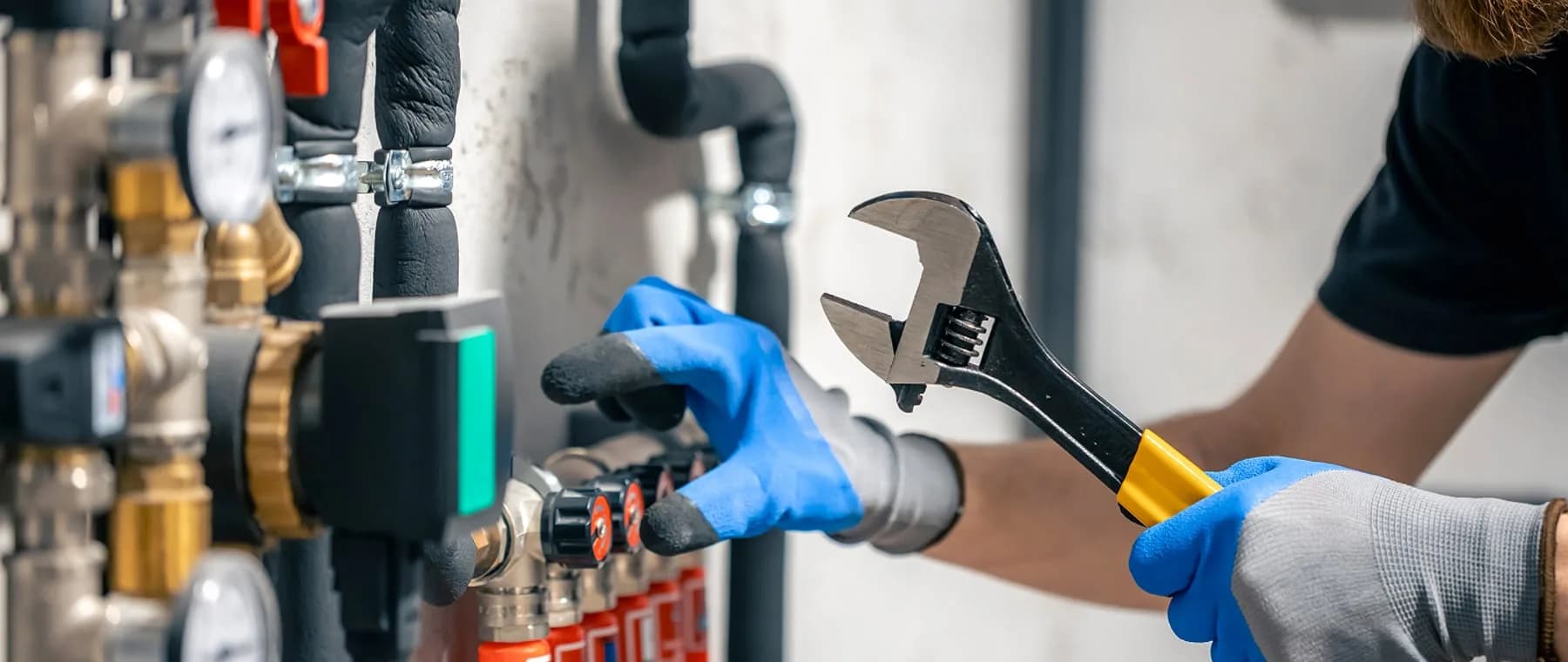 Mains gantées serrant un raccord avec une clé